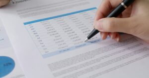 Stock trader agent or MBA student learn tax wealth working at lawyer office use pen
