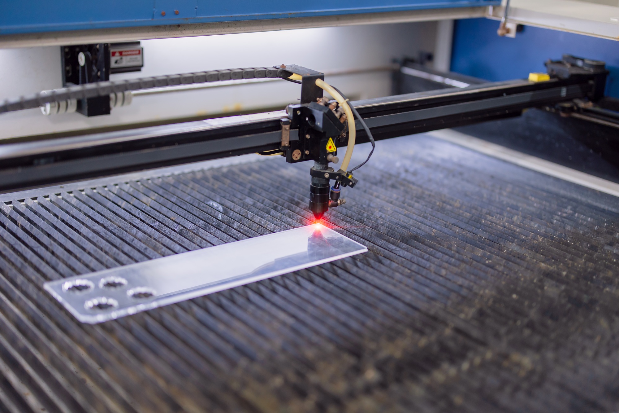 industrial CO2 laser cutting machine working with high powered red laser beam on acrylic